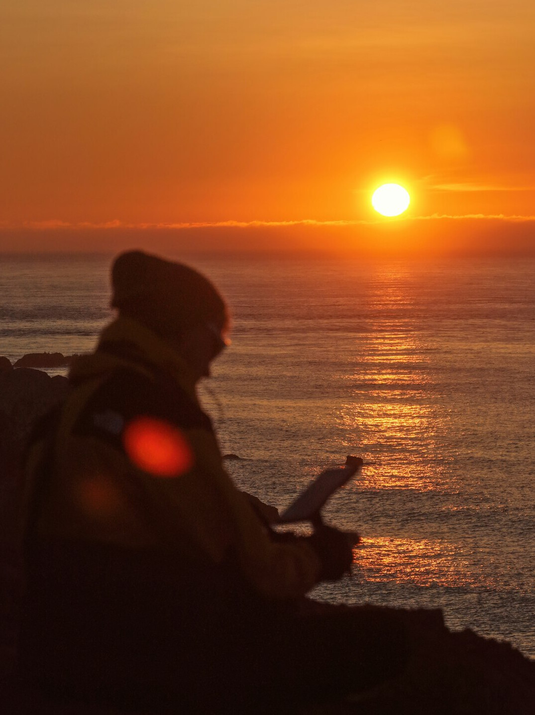 person writing in journal at sunrise