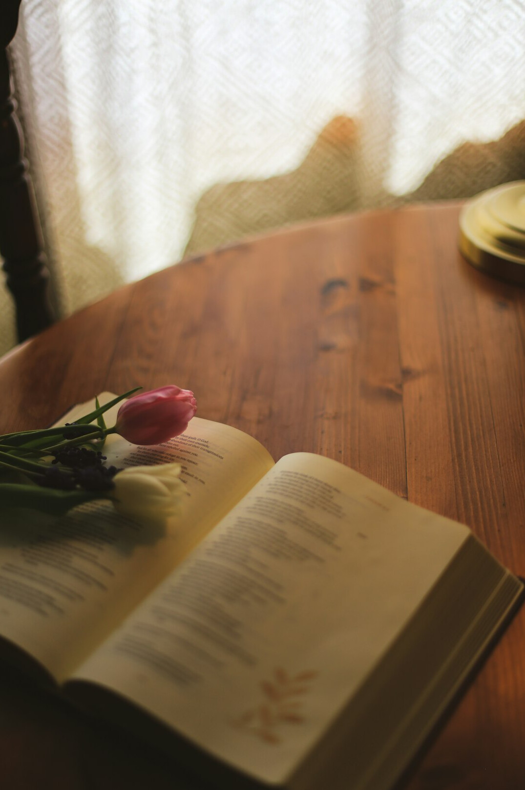 Stack of books and an open notebook on a wooden table