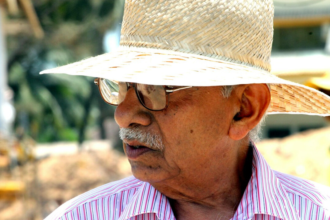 Studio portrait of an older Mexican man with glasses