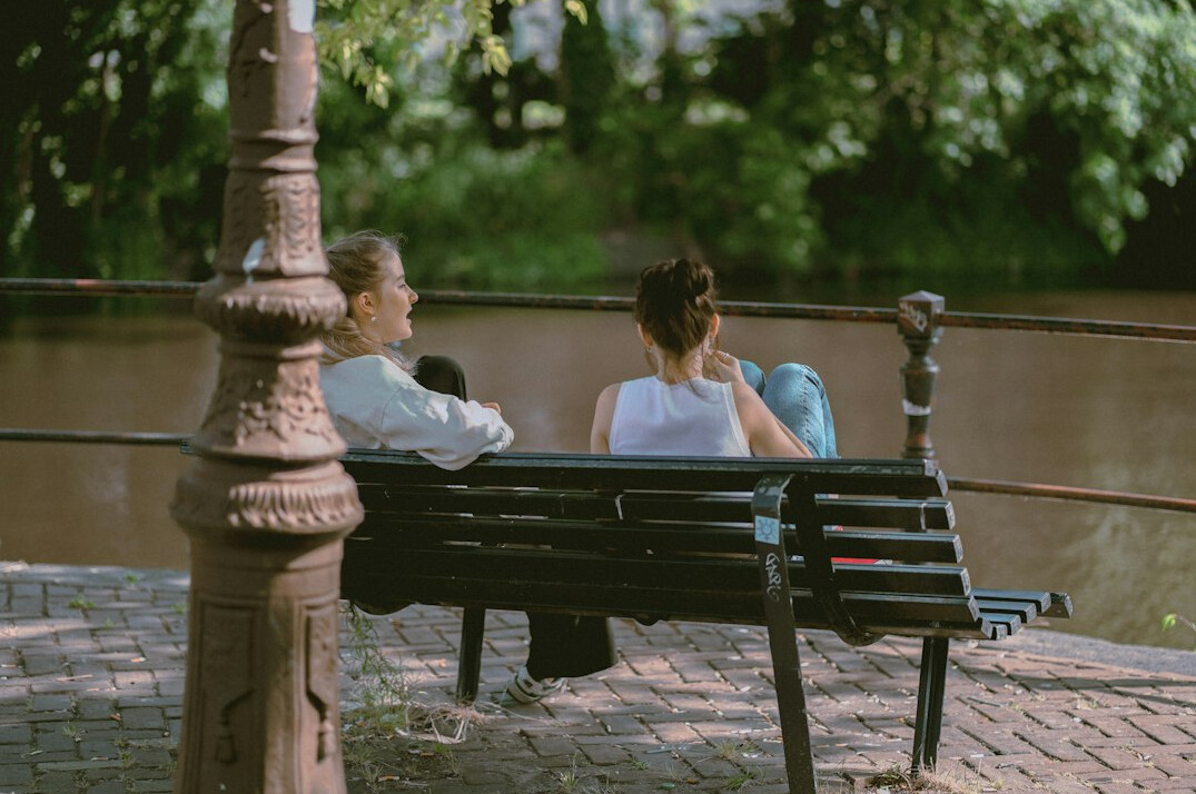 Two people having a genuine conversation on a park bench